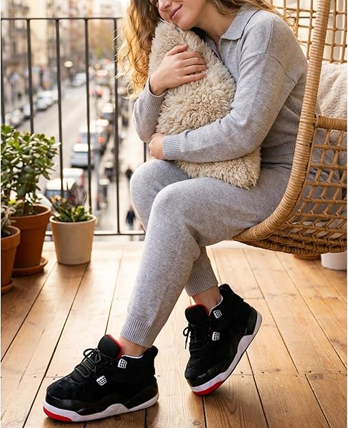 Woman wearing black sneaker style house slippers indoors